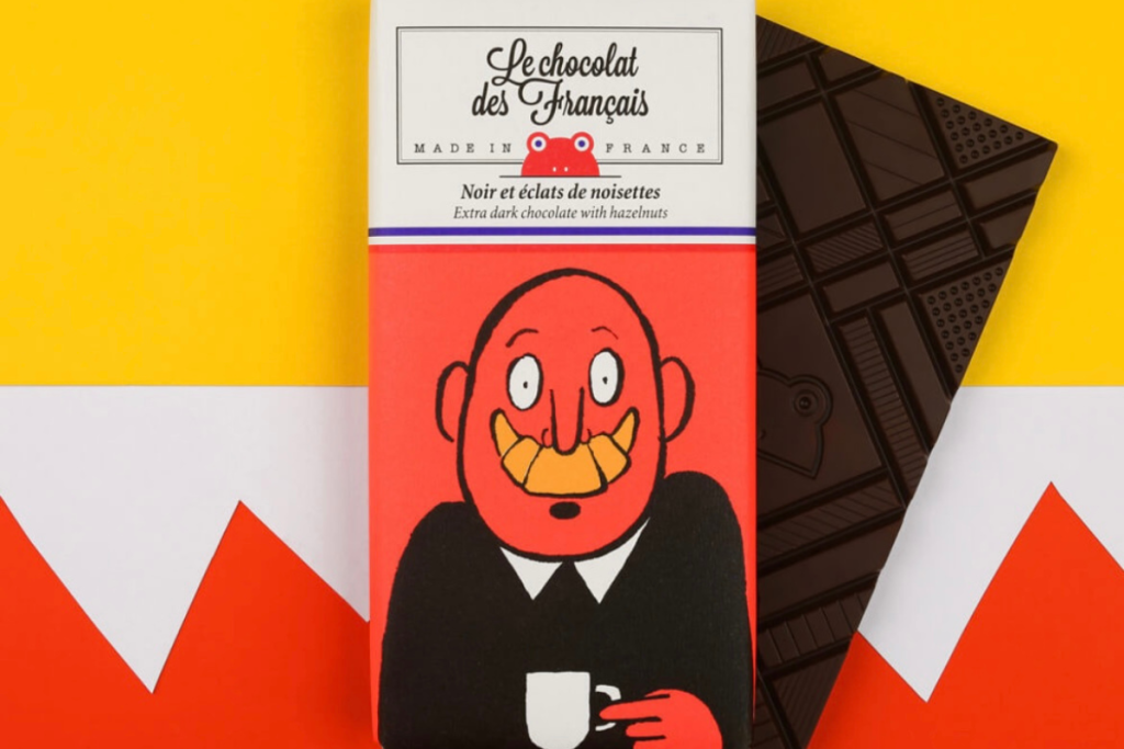 Tablette de chocolat noir aux éclats de noisettes croquantes, fabriquée en France par Le Chocolat des Français. Chocolat artisanal intense, avec un packaging illustré et coloré au style pop.