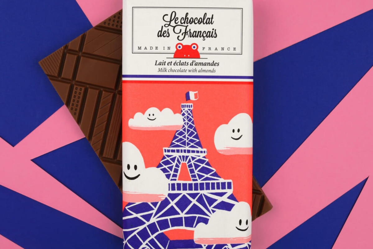 Tablette de chocolat au lait aux éclats d’amandes croquantes, fabriquée en France par Le Chocolat des Français. Chocolat artisanal fondant avec un packaging illustré original et coloré.
